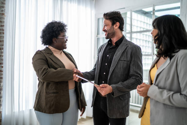 istock Real estate agent greeting a customer in a house 1477901942
