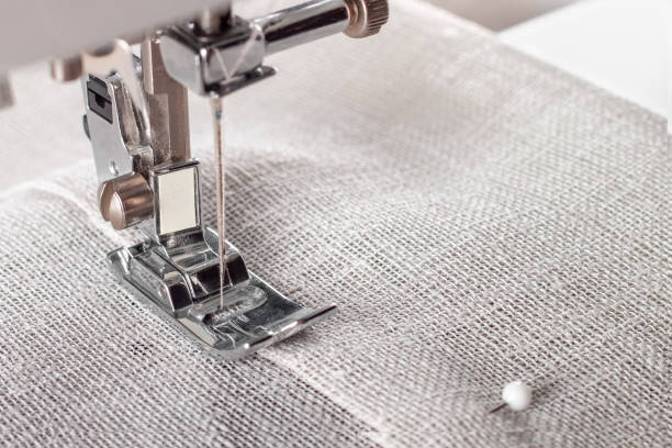 istock Modern sewing machine presser foot with linen fabric and thread, closeup 1477902067