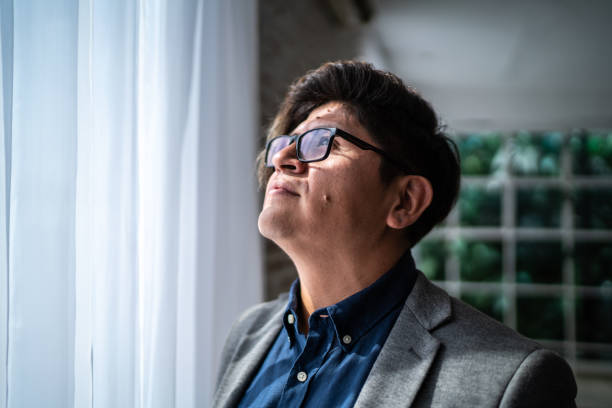 istock Mid adult man contemplating while looking through the window 1477902629