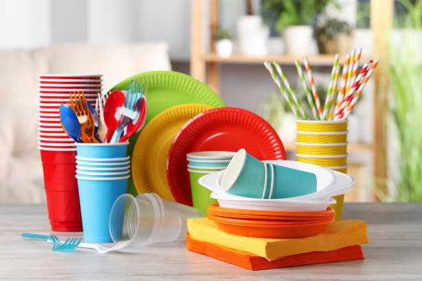 Bright disposable tableware c on wooden table indoors
