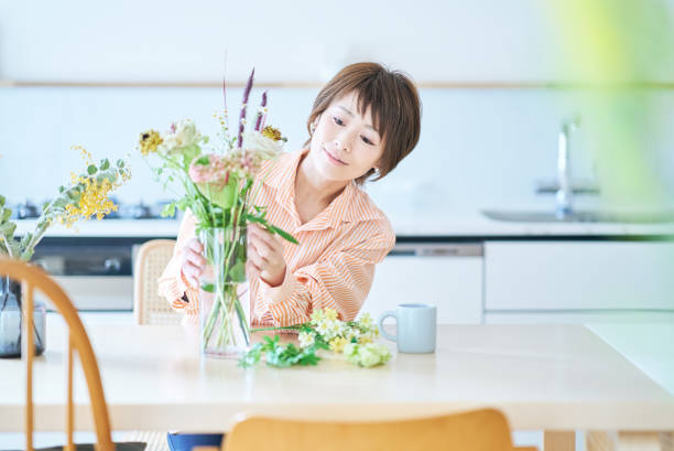 istock Woman arranging flowers with flower vase 1477903921