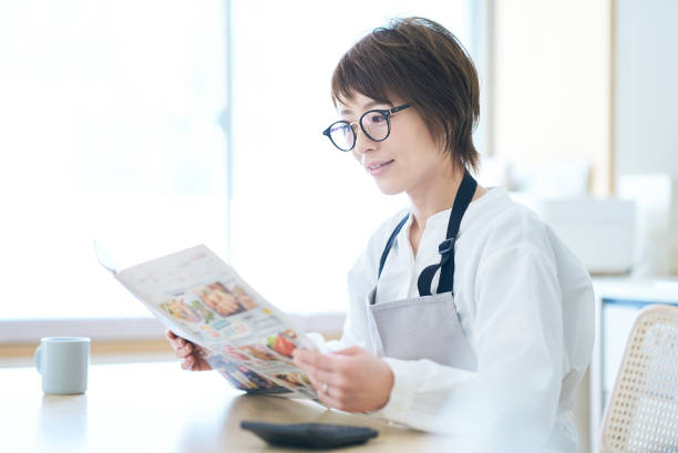 A woman wearing glasses looking at an advertising leaflet