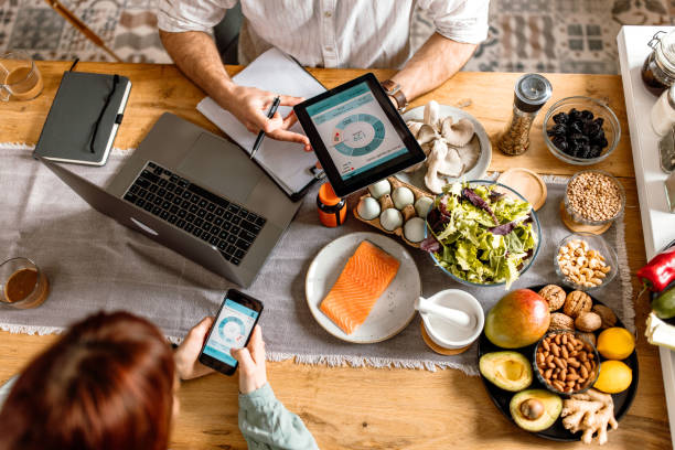 istock Patient tracking health parameters with mobile app during nutritionist consultation 1477929652