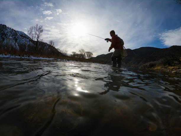 istock Man Fly Fishing Along River Low Angle View 1477931224