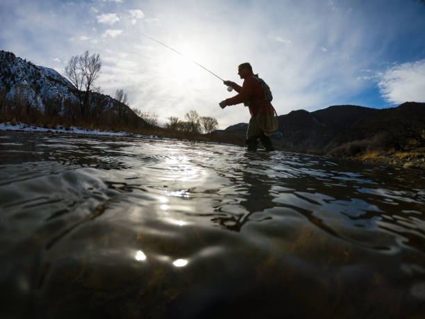 istock Man Fly Fishing Along River Low Angle View 1477931297
