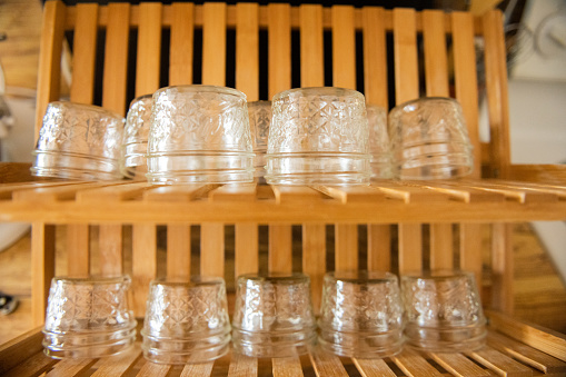 This is a close up of two rows of clean reusable glass jars drying upside down on a drying rack in Miami, Florida USA.