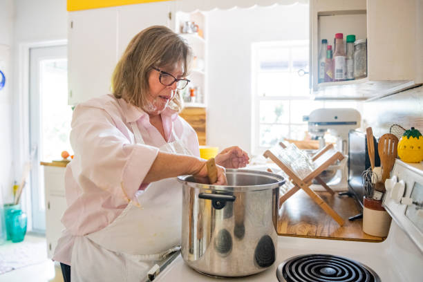 istock Cooking Woman Stirs a Boiling Pot in the Kitchen 1477935387