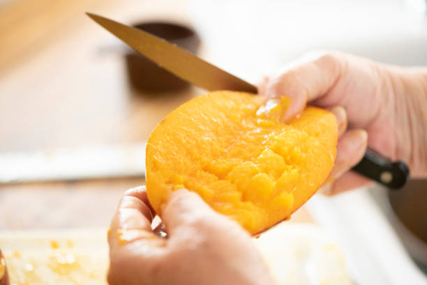 istock Miami Woman Cutting Homegrown Mango in Kitchen 1477935577