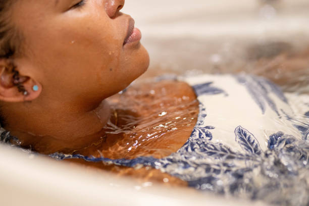 jeune femme profitant d’un bain relaxant dans un bain à remous - hidromassage inside of wet luxury photos et images de collection