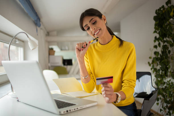istock Cheerful  woman doing online shopping 1477940369