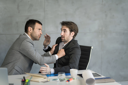 Frustrated manager confronting an employee in the office.