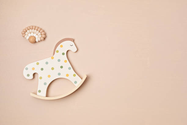 istock Cute rocking horse toy and teether on beige background 1477940780