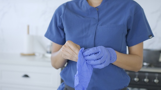 home caregiver putting gloves on for preparing food during a home visit