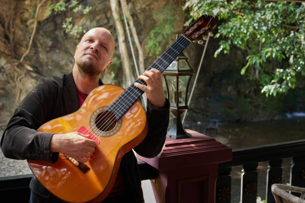 istock Man playing guitar with expression amidst nature's beauty 1477941109