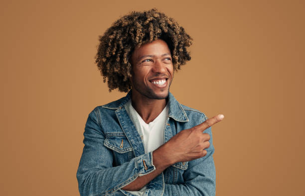 istock Cheerful black man pointing away in studio 1477941272