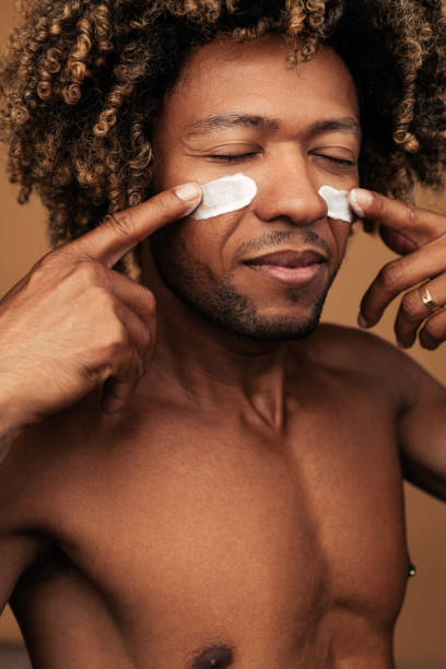 istock Calm black male spreading cream on cheeks 1477941539
