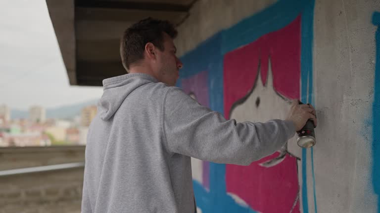 Artist painting graffiti on wall