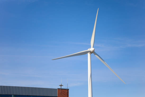 istock wind turbine standing tall against a clear blue sky, symbolizing sustainability, renewable energy, and the use of alternative energy resources in industry 1477946957
