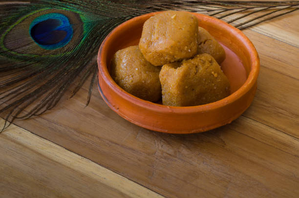 Mathura ka peda is served on a clay plate with peacock feather during celebration of Krishna janmashtami. This traditional Indian sweet originated in mathura is made of khoya or Mawa, ghee and sugar.