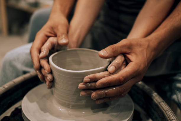 istock Couple mold ceramic vase in a pottery workshop, hands close up. 1477949309