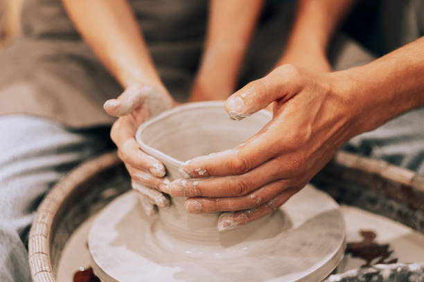 istock Couple mold ceramic vase in a pottery workshop, hands close up. 1477949393