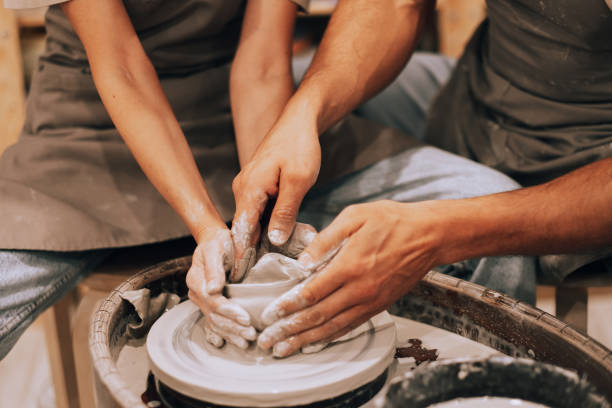 istock Couple mold ceramic vase in a pottery workshop, hands close up. 1477949941