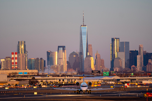 Airplane is going on taxiway after landing in International Newark airport the USA. Aircraft on background of New York