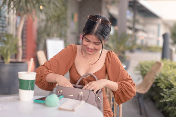 uma adolescente bonita senta-se do lado de fora da bolsa e procura seu pente de cabelo. - puffed sleeve - fotografias e filmes do acervo