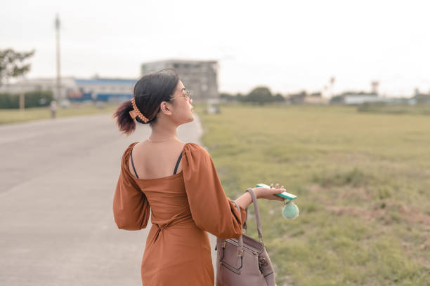 uma jovem que mostra as costas olha para a direita com o queixo para cima para ver a vista do campo aberto. - puffed sleeve - fotografias e filmes do acervo