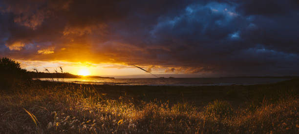 Panorama of bright sunrise and storm on the coast