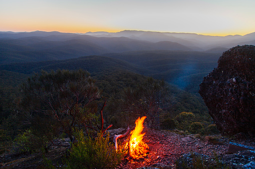 Camp fire in the mountains with rolling landscape background