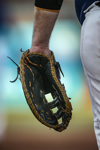 Baseball first baseman with glove on his left hand, closeup, photo shows glove, left arm and left hand of first baseman, no faces shown in photograph