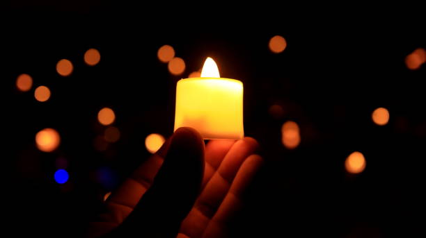 istock Candles glowing against dark background closeup 1477977853