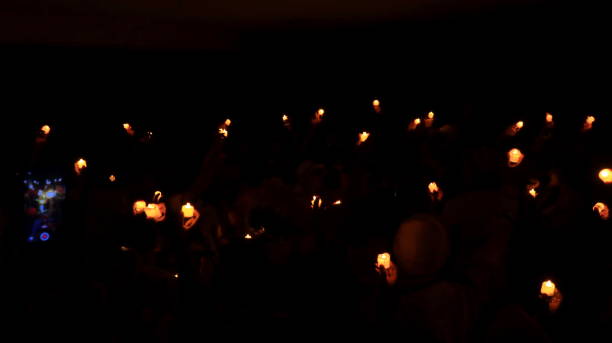istock Candles glowing against dark background closeup 1477977854