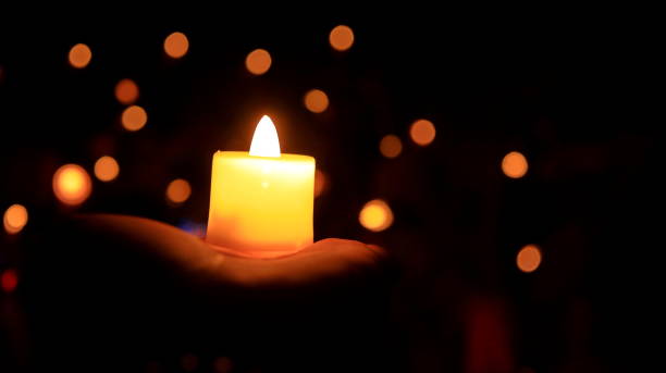 istock Candles glowing against dark background closeup 1477977860