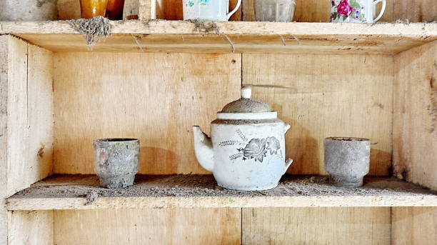 istock Old wooden cupboard with dirty and old clay pots 1477977952