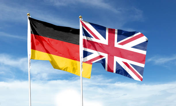 istock Union Jack and German flag on cloudy sky. waving in the sky 1477980294