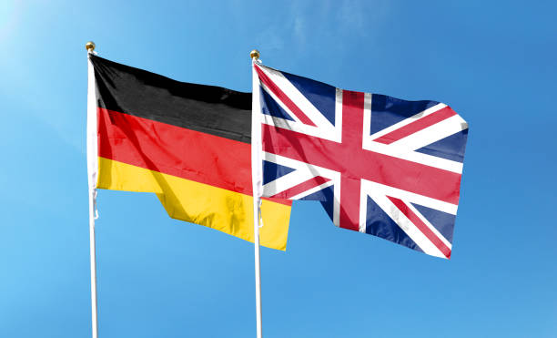 istock Union Jack and German flag on cloudy sky. waving in the sky 1477980295