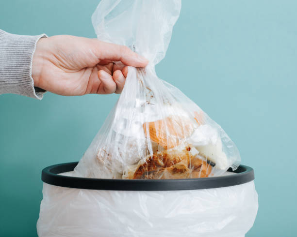 istock Close-up hand throws out garbage, food leftovers in bag into the trash can 1477980312