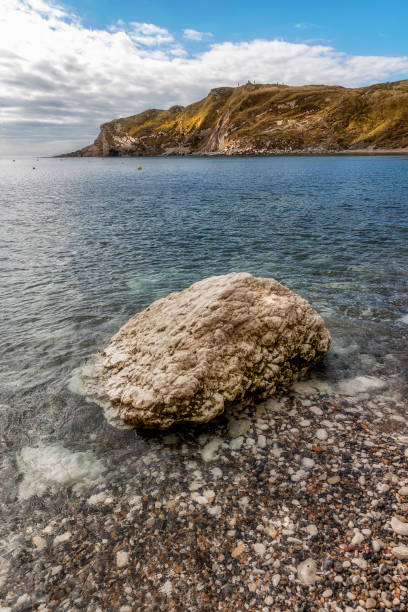 Boulder fallen from cliffs onto narrow beach