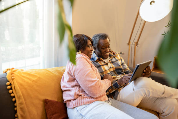 istock elderly couple video call with a tablet on the sofa at home 1477993121
