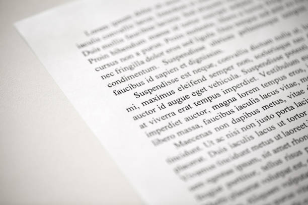 istock Lorem Ipsum dolor text on printed on paper in black and white, sample of document, side view, selective focus 1477994249
