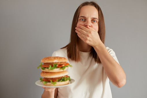 young man eating a juicy hamburger.Others food photographs in this lightboxe:
