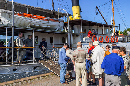 Hjo, Sweden-July, 2015: People queuing to board an old ship in Hjo harbor, Sweden