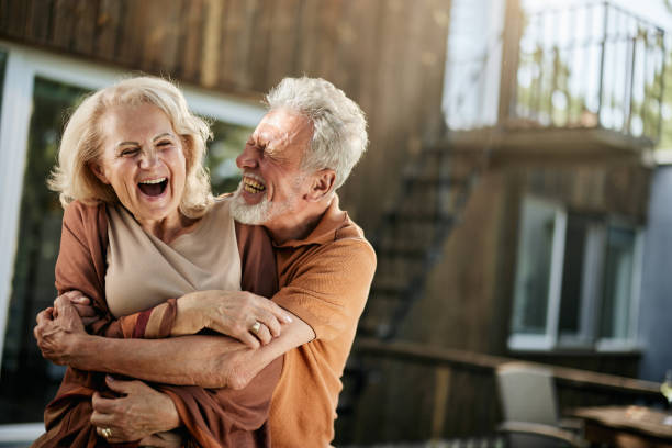 istock Cheerful senior couple having fun while embracing on a terrace. 1478005910