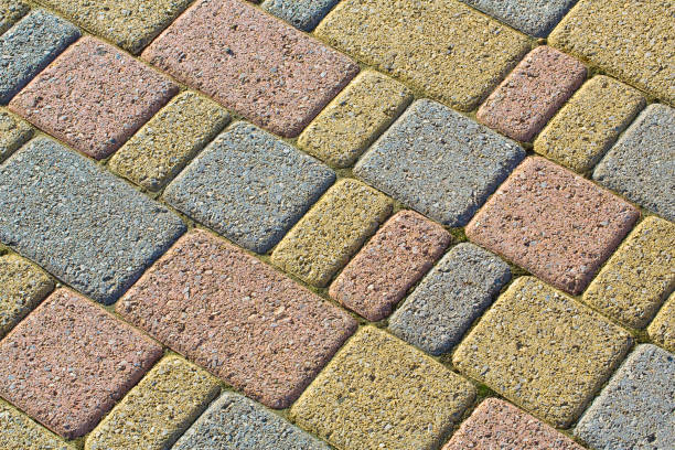 betonowe betonowe bloki samoblokujące montowane na podłożu z piasku - rodzaj posadzki przepuszczającej wodę deszczową zgodnie z wymogami prawa budowlanego - driveway brick paving stone interlocked zdjęcia i obrazy z banku zdjęć