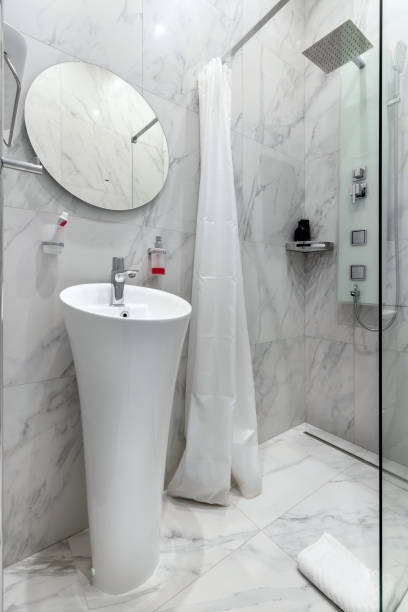 istock Modern renovated bathroom with a white shell, mirror and marble wall 1478010203