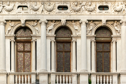 Ornate marble arcades with crown glass windows of the Marciana Library or Library of Saint Mark completed in 1588 by Jacopo Sansovino on Saint Mark's Square in Venice