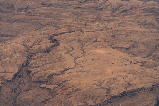 dramatic aerial view of the texture and patterns on the barren desert landscape from an airplane in the middle east.