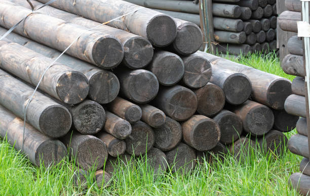 Pile of wooden poles for construction, selective focus